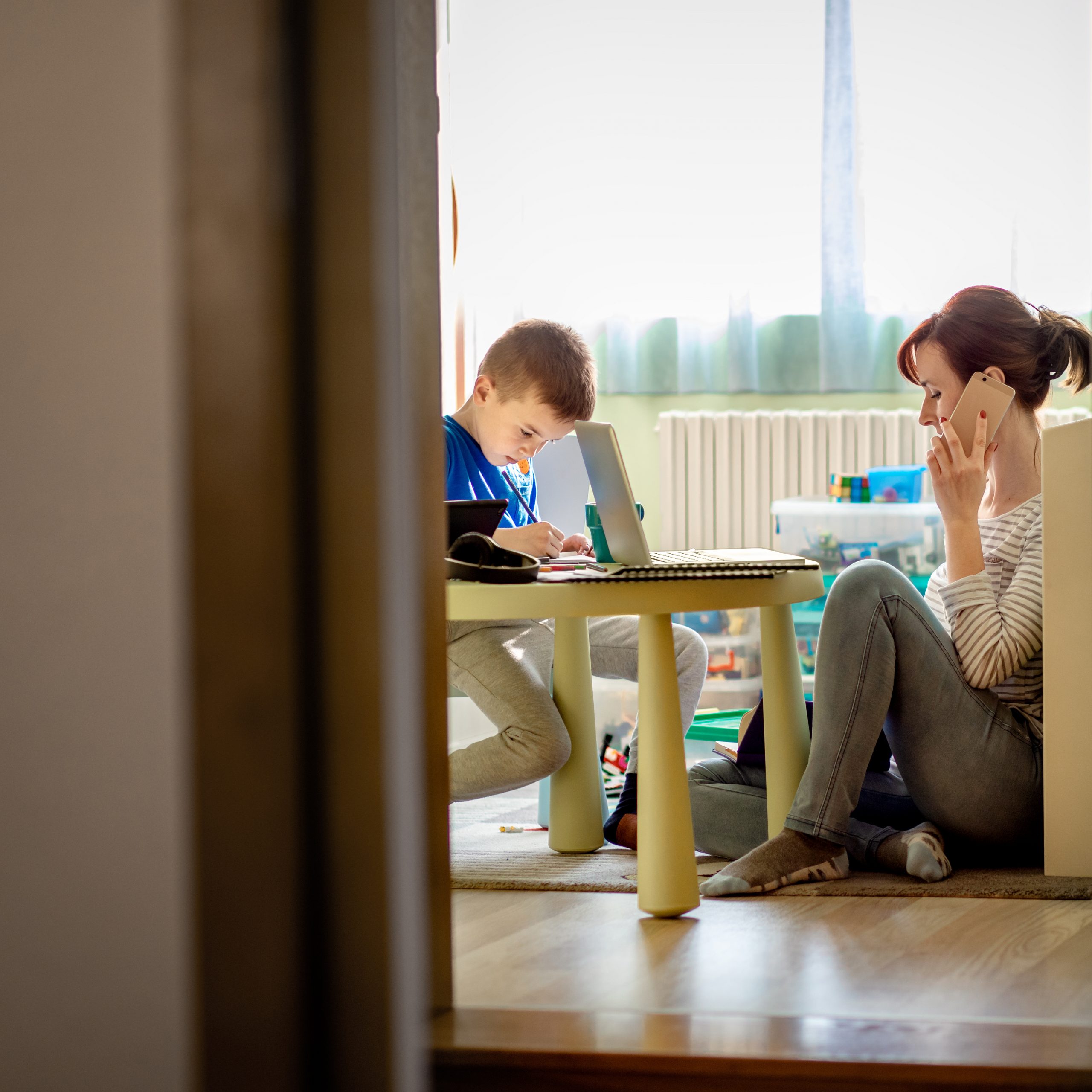 Mother on the phone while taking care of her son